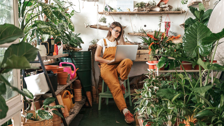 Small business owner sitting among her many plants.