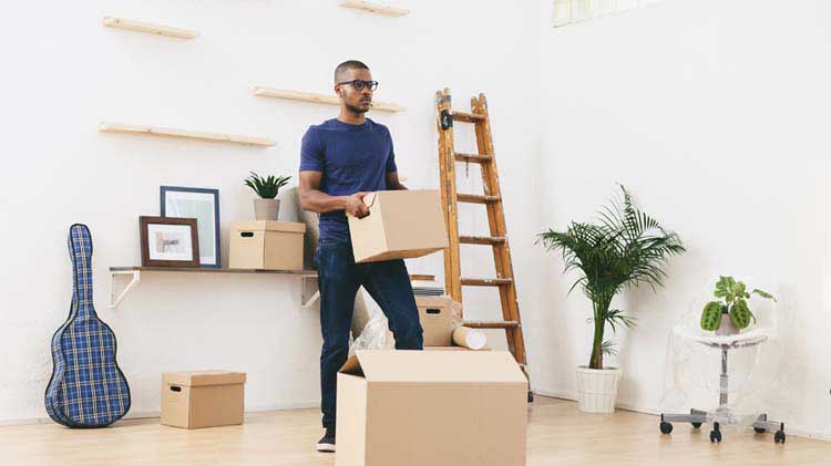 Person holding a box and thinking about what he needs to do to be ready for move in day.