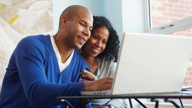 Man and woman looking at a laptop.