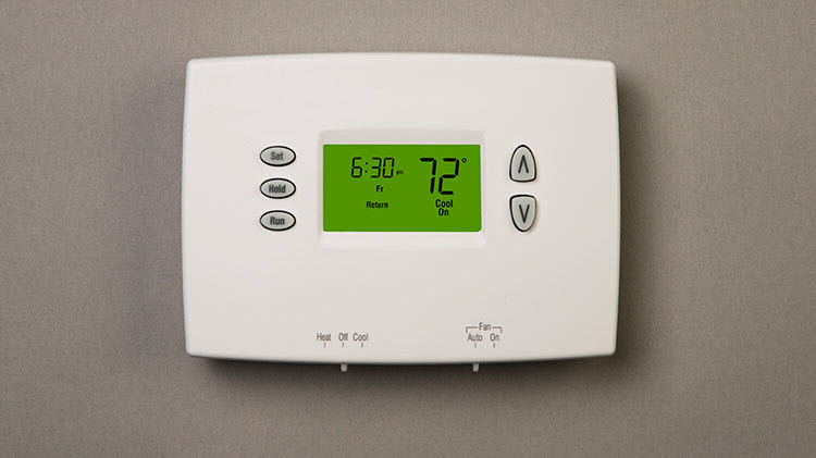 A home thermostat showing the time and temperature.