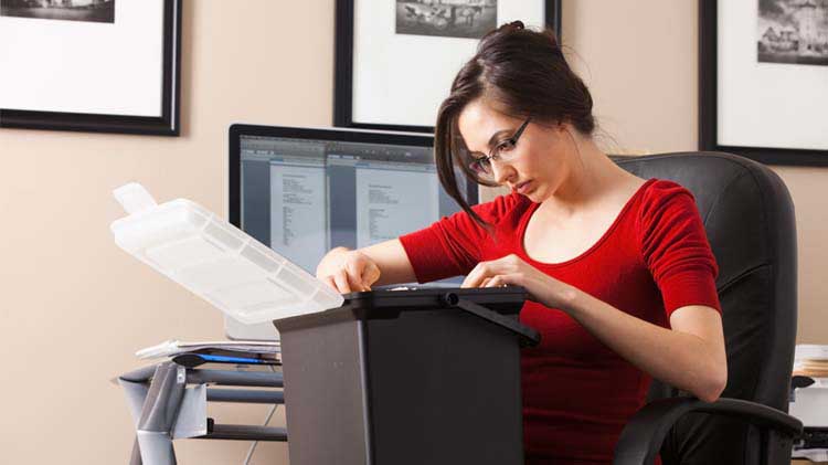 Woman reviewing file box of documents.