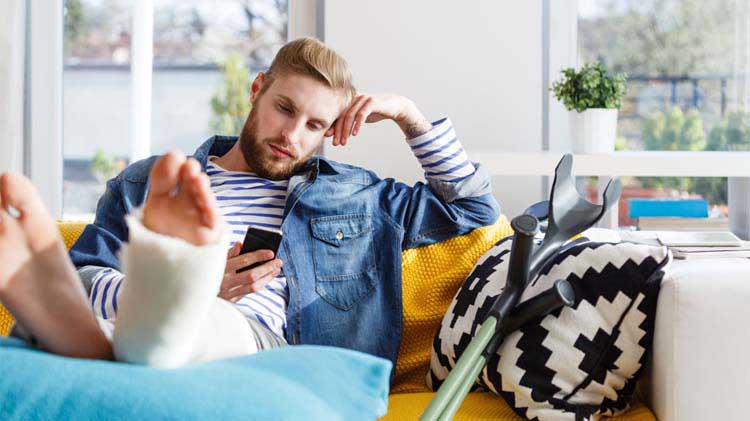 Man with an injury looking at his disability insurance benefits on his phone