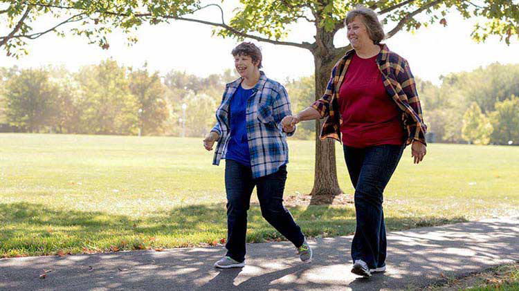 Mother walking with special needs child.