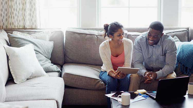 Couple sitting in living room working on taxes.