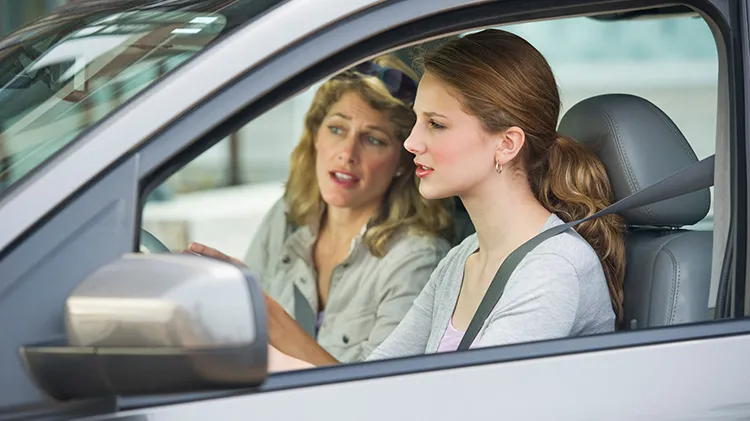 Mother teaching her daughter how to drive.