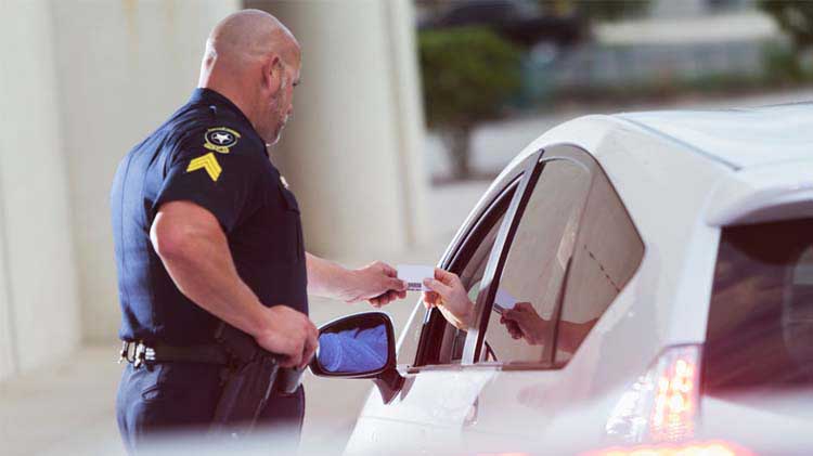 Policeman receiving driver's license during a stop.