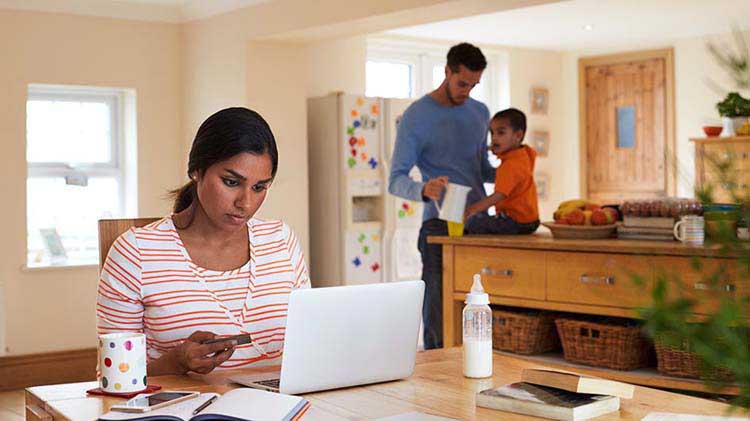 Woman at her laptop reviewing social media settings to ensure her personal information is protected.