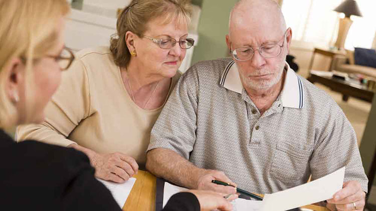 An older couple looks over a will with an attorney.