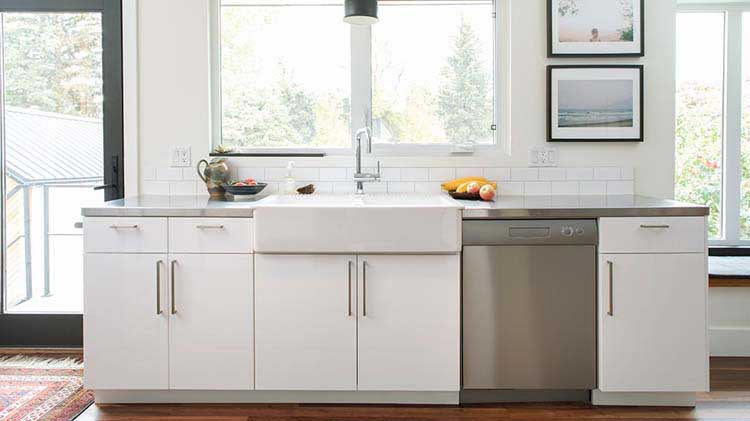 Display of kitchen counter with lower cabinets, sink and dishwasher.