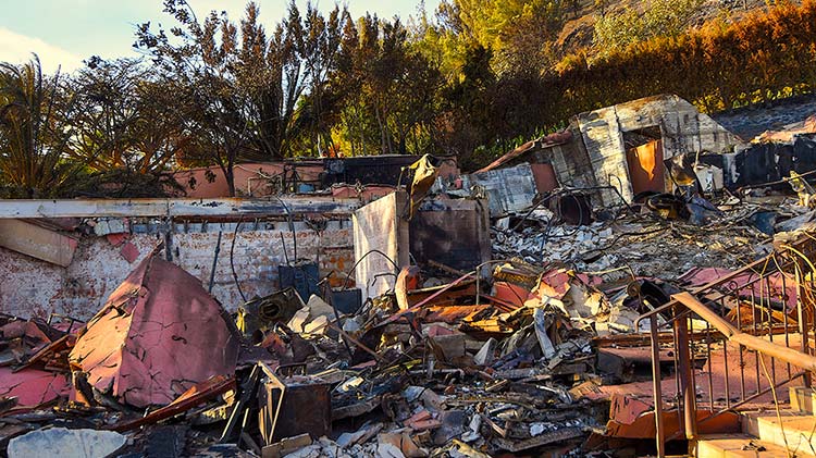 A home is completely destroyed by a wildfire.