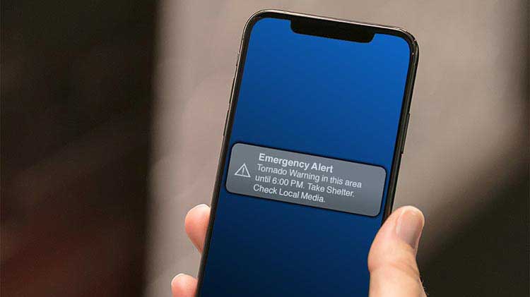 Mobile phone displaying emergency alert for tornado warning.