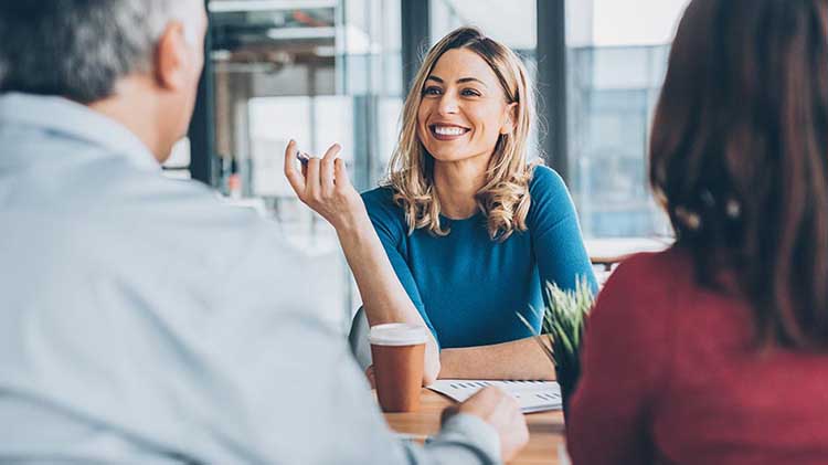 A financial advisor meeting with a couple who's backs are to the camera.