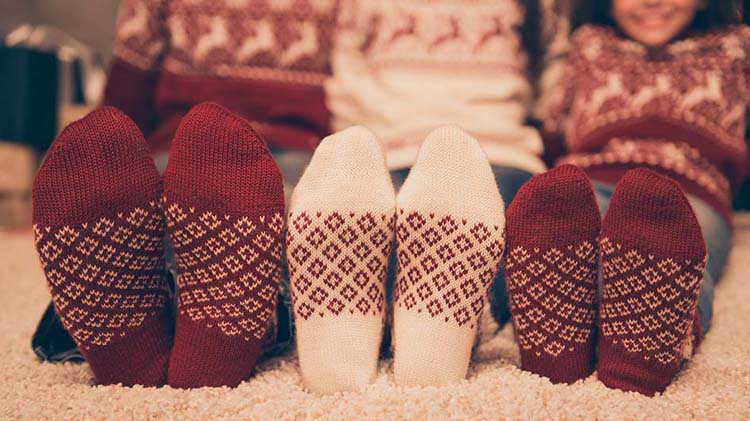 Three pairs of feet in warm cozy socks.
