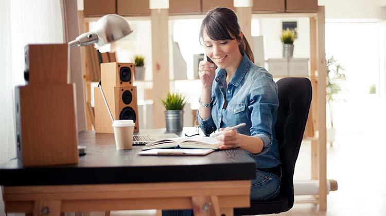 Woman on the phone working at her desk.