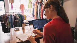 La empleada de una tienda mirando un cuaderno.