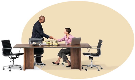 Two people at a desk shaking hands