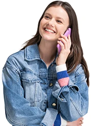 A young woman in a denim jacket talks on her smartphone.