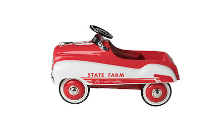 Photo is of a red-and-white child’s pedal car. The car features the words “State Farm” and “Like a good neighbor.” The car features a black steering wheel, a silver hood ornament, black-white-red wheels, and the number “5” on the car’s hood.