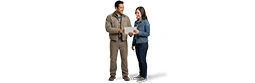 A contractor with dark hair, a tan jacket, flannel shirt and work pants holds a tablet with a customer in a denim jacket and jeans. Both are smiling.