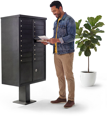 Junto a una planta en maceta, un hombre revisa su correo en un buzón de correo comunitario de color oscuro.