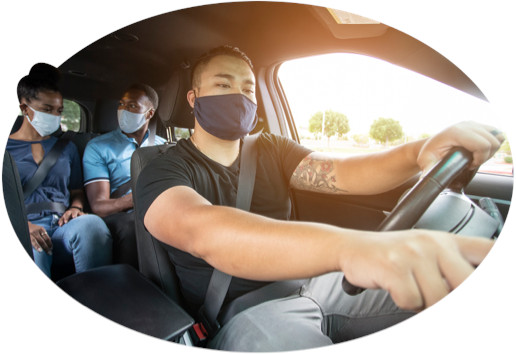 With two masked passengers in the back, a masked rideshare driver checks directions.
