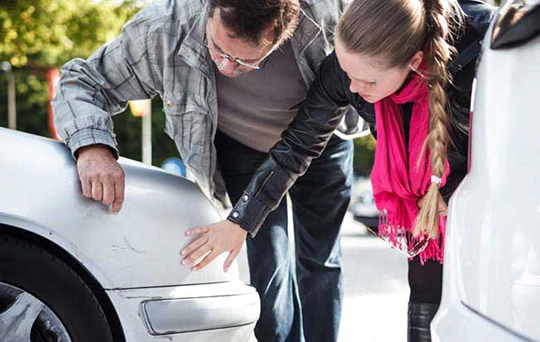 A couple examine the damage to their front passenger side scratch.