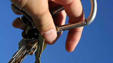 A pair of keys dangles from the hand of a new driver.