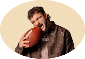 A football player biting a football.