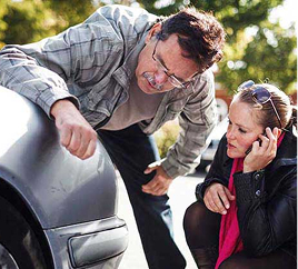 couple looking at car damage