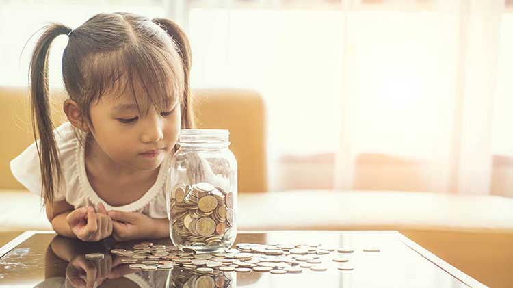 Young girl looking into jar of coins.