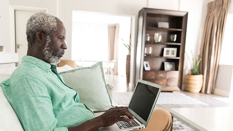 A man uses his laptop to work on his will and estate planning.