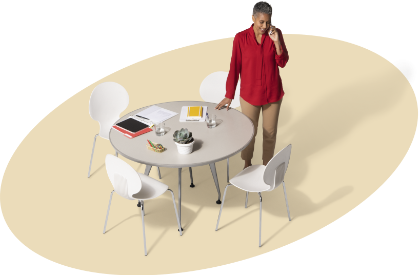 Woman on a phone call standing next to a table